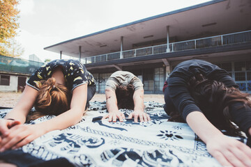 Sportive athletic fit group stretching outdoors practicing intense workout