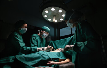 Medical team performing surgery in operation room.