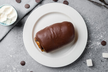 bun with poppy seeds and chocolate top view on grey table