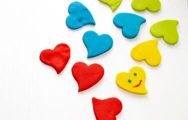 clay plasticine hearts kid child hand diy do it yourself activities happy valentines day february 14th.blue yellow colour heart isolated.smile sad emotion emoji creative little preschooler boy