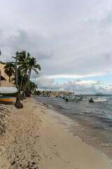 Fototapeta na wymiar Fishing boats on the white coast of the Caribbean Sea in Playa Del Carmen.