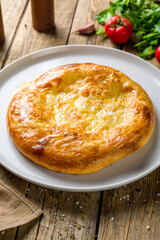khachapuri with cheese, megrelian khachapuri, georgian cuisine on wooden table vertical