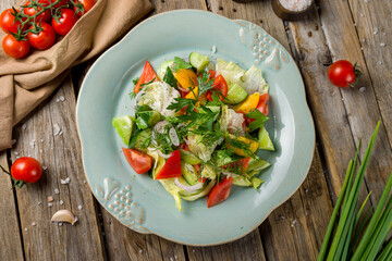 Vegetable salad with tomatoes and cucumbers and bell pepper top view on wooden table