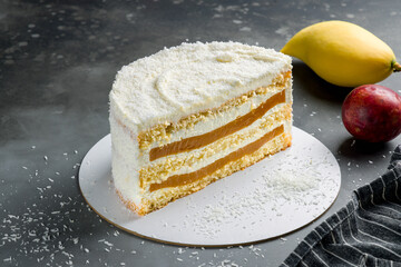 mango passion fruit cake with coconut chips on grey table