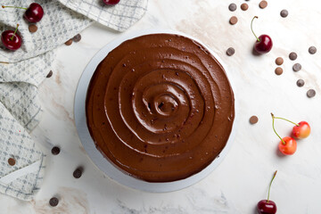 chocolate cake with cherries on white marble table top view