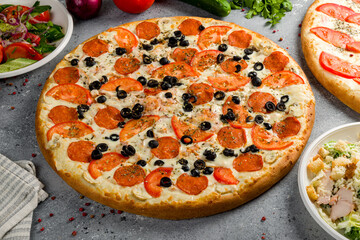 Italian meat pizza with cheese on grey table side view
