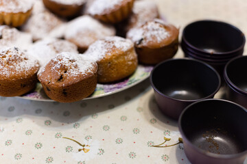 Cupcakes cutters and homemade cupcakes topped with powdered sugar on the table. Selective focus.