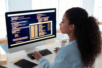 Serious female programmer writing code for testing computer software