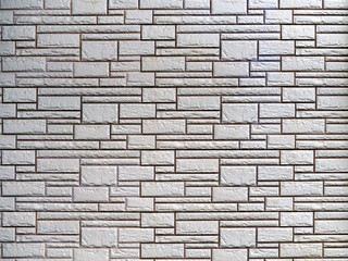 The gray brick wall consists of rough decorative bricks of various sizes and shapes. Abstract geometric stone background.