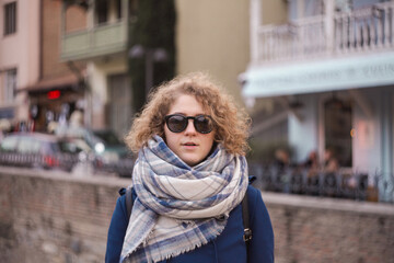 beautiful curly young woman in glasses outdoors in cold weather