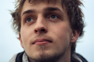 young man looks hopefully into the distance