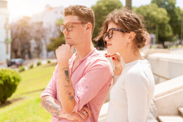 Young beautiful hipster couple in sunglasses in love walking on old city street