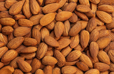 Peeled almonds background closeup. Vegetarian food concept. Raw almond nuts wallpaper.