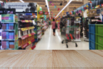 Wooden table top (counter bar) with blur supermarket grocery store background. Banner for advertise on online media. For montage product display visual layout. Business and shopping concepts.