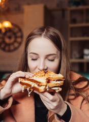 beautiful young woman in a cafe eating a sandwich