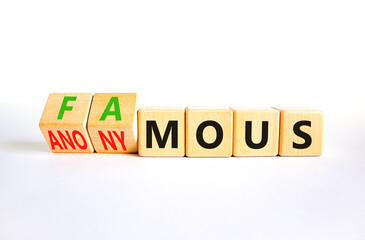 Fototapeta premium Famous or anonymous symbol. Concept word Famous and Anonymous on wooden cubes. Beautiful white table white background. Business famous or anonymous concept. Copy space.