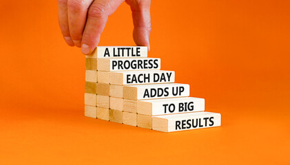 Progress and result symbol. Concept words A little progress each day adds up to big results on wooden blocks on a beautiful orange background. Businessman hand. Business future in your hands concept.