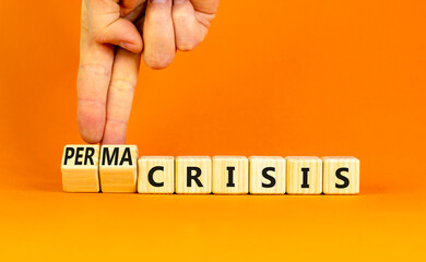 Permacrisis or crisis symbol. Concept words Crisis and Permacrisis on wooden cubes. Businessman hand. Beautiful orange table orange background. Business permacrisis or crisis concept. Copy space.