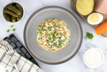 Russian olivier salad and ingredients for cooking on a gray background, top view. Russian Olivier salad. Russian New Year salad 