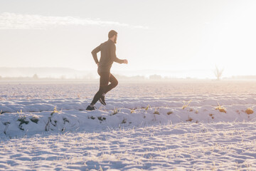 Man running on a road in winter