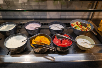 on a breakfast buffet there are different kinds of yogurt and fruit
