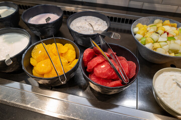 on a breakfast buffet there are different kinds of yogurt and fruit