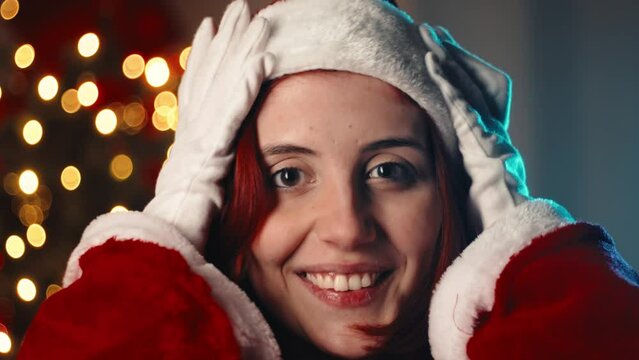 Girl wear the Christmas red hat against the tree