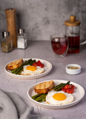 Food photography of fried egg, tomato, asparagus, toast, tea, salt, breakfast
