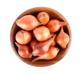 Brown mini onions in wooden bowl, isolated on a white background. Raw onion bulbs, for cultivation. French onion. Top view.