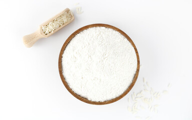 Wooden bowl with rice flour and whole grains. Rice flour isolated on white background. View from above.