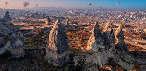 Cave in big stone, hot air balloons fly over deep canyons, valleys Cappadocia Goreme National Park, Banner Turkey Travel