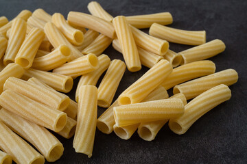 Raw italian penne rigate pasta isolated on black background