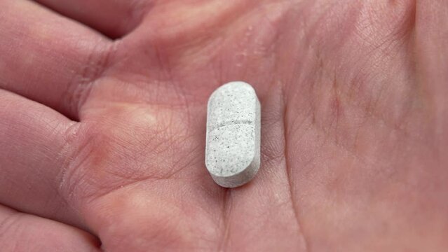 Sedative pills with tryptophan in hand close-up. Remedy for depression and insomnia. Natural pharmaceutical antidepressant