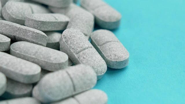 Tryptophan sedative pills on a colored blue background. Medical remedy for depression and insomnia. Natural pharmaceutical antidepressant. Rotation