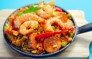 Delicious paella, cooked risotto rice with chicken thigh, king prawns, tomatoes and  chorizo