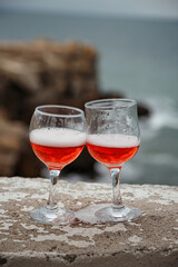 Two glasses of pink champagne on the handicap of the mountains and the sea. Travel and romance. Beautiful landscape. recreation and alcoholic beverages.