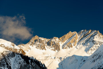 Alpine mountain peaks glow in the winter evening sun