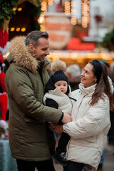 Beautiful happy family at the Christmas market. Winter holiday. Holidays in Europe. New Year.