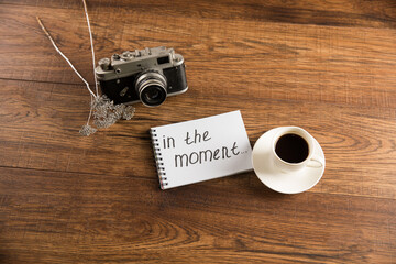 The inscription in the moment, a cup of coffee and an old camera
