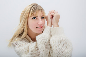 close up portrait of blonde girl model in white wool sweater on white background in studio