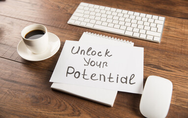 The inscription Unlock your potential and coffee, notepad and keyboard