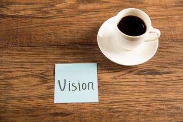 The inscription vision on the sticker and a cup of coffee
