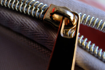 Selective focus, yellow metal zipper of a makeup bag or small purse macro pattern background