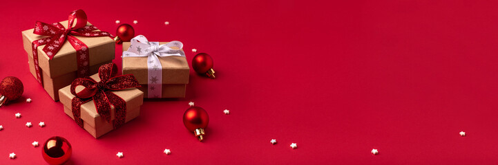 Christmas gift boxes with red balls on red background.