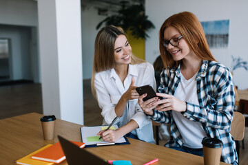 Content women collaborating using smartphone