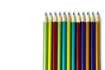Colored pencils isolated on a white background, a place for information.