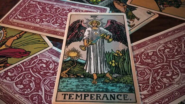 Tallinn, Estonia - June 1, 2016. Deck of cards for a spell casting ritual. Casting the spell during a magic ritual with the tarot card Temperance from the deck. Deck for paranormal spell ritual