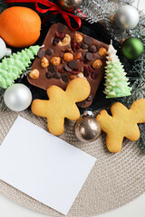 Cristmas presents. christmas sweets. chocolate with nuts and candied fruit, gingerbread, tangerines, Christmas tree branches and Christmas balls	