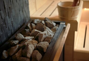 Fototapeta na wymiar Sauna bucket with water beside the stone in finnish sauna room.