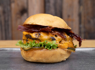 Hamburger. Closeup view of a burger with grilled meat, lettuce, cucumber pickles, cheddar cheese...